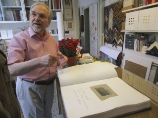 Josef Weiss nel suo atelier a Mendrisio, mentre mostra una delle sue preziose edizioni