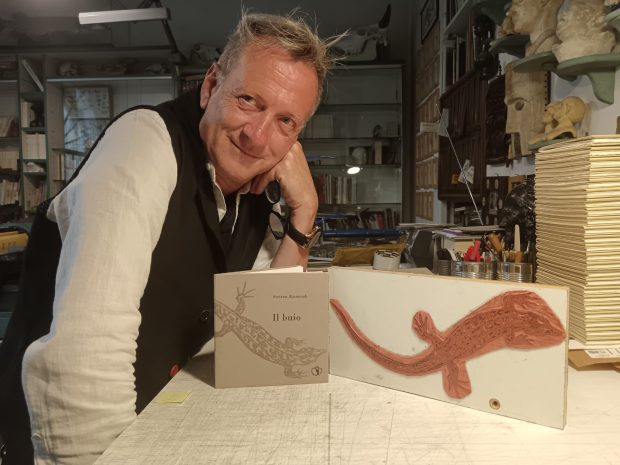 Stefano Raimondi nell’ atelier milanese di Luciano Ragozzino con il libro d’’artista Il buio, edizione Il ragazzo innocuo, 2025 -scatto di Elisabetta Motta